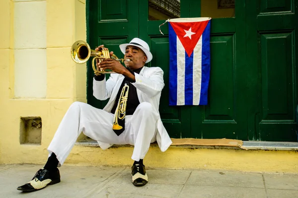 Starý muž hudebník latino v ulici Havany. Kubánská vlajka visí na dveřích — Stock fotografie