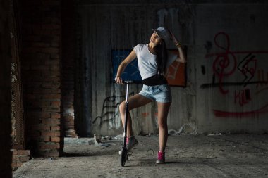 Genç sporcu kadın onu tekme scooter duran ve arıyorum bana yardımcı olanvarmı