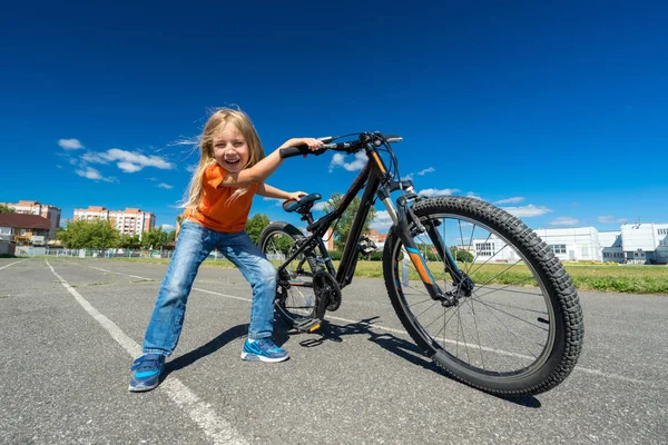 Sonriente niña con su bicicleta al aire libre en la pista en bri — Foto de Stock