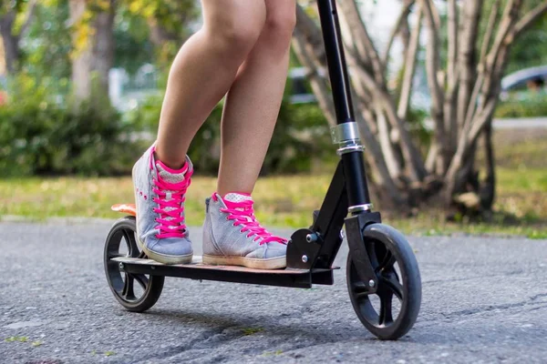 Athlète adolescente monte sur un scooter kick dans le parc à la journée ensoleillée d'été — Photo