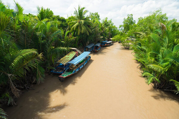 Empty boats are parked near a coastline of tropical river with m