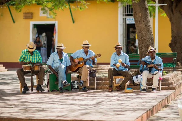 拉丁裔男子音乐家群玩吉他、 maracases 和鼓 图库图片