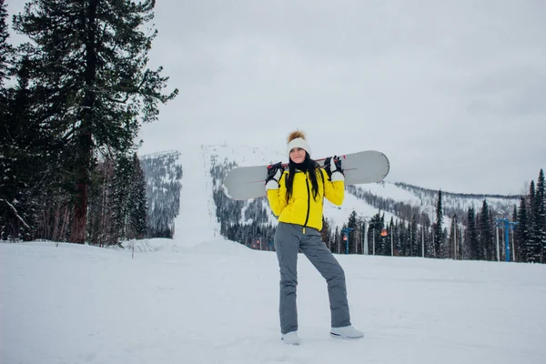 Schöne junge Frau in gelber Jacke und Winterkleidung lächelt — Stockfoto