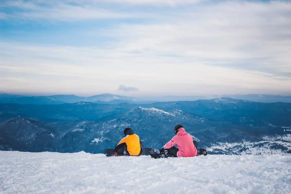 Deux snowboarders sportifs s'assoient et se préparent à descendre de la neige — Photo
