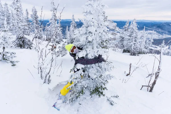 Jeune femme en bonnet jaune vif, masque de ski et embr snowboard — Photo