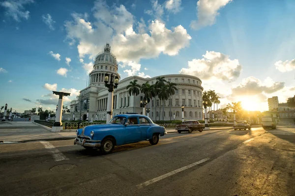 Синий ретро-автомобиль едет рядом со старинным зданием Капитолия — стоковое фото