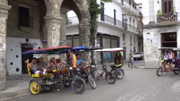 Trishaws utan passagerare är parkerade på turistiska street nära torget i Havanna på regnig sommardag — Stockvideo
