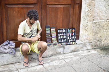 Yerel sanatçı adam onun el yapımı iş takı bijou St satıyor