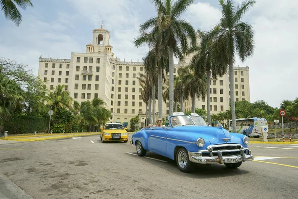 Blauwe retro auto en taxi rijden van bouw van hotel Nation — Stockfoto