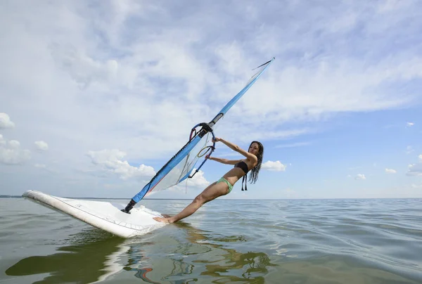 Jeune belle femme pose sur le bureau de surf dans la mer — Photo