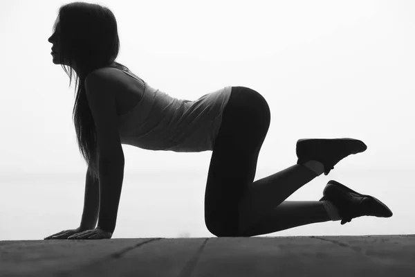Черно-белый силуэт молодой красивой спортивной женщины это делать — стоковое фото