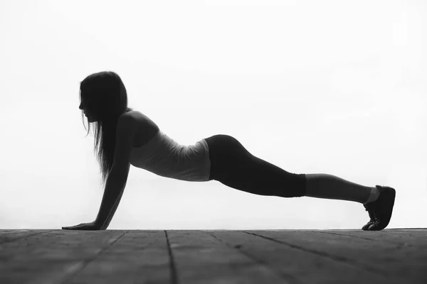 Black and white silhouette of beautiful young sporty woman press — Stock Photo, Image