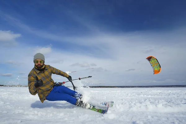 Sportsman in bright clothes rides with kite on winter snow-cover — Stock Photo, Image