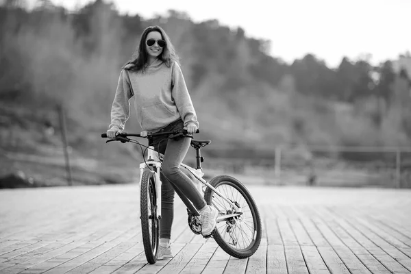 Belle jeune femme brune en vêtements de sport promenades sur son vélo — Photo