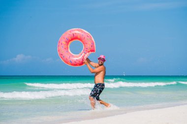 Mutlu gülümseyen yakışıklı pembe şapka ile büyük bir inflata standları