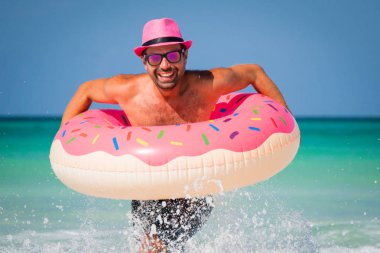 Mutlu pembe şapkalı yakışıklı komik adam büyük yayılması ile eğleniyor