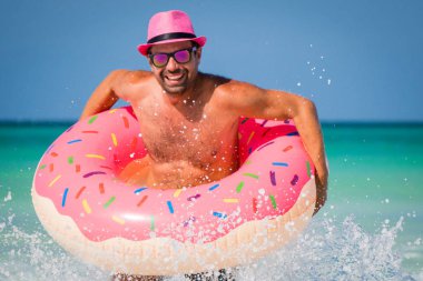 Mutlu yakışıklı gülümseyen adam pembe şapkalı eğleniyor ile büyük içinde değildir