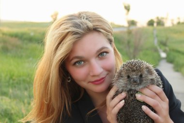 bir kirpi tutan genç kız