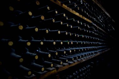 Şarap şişeleri bir raf içinde depolanan.