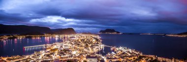 Alesund gece manzarası. Bulutlu havalarda deniz kenarında gece şehir panoraması.