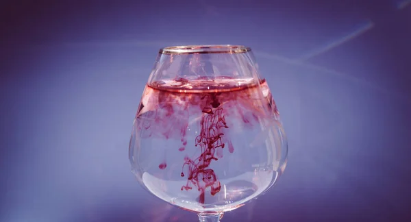 Wijnglas gevuld met rode en gele inkt — Stockfoto