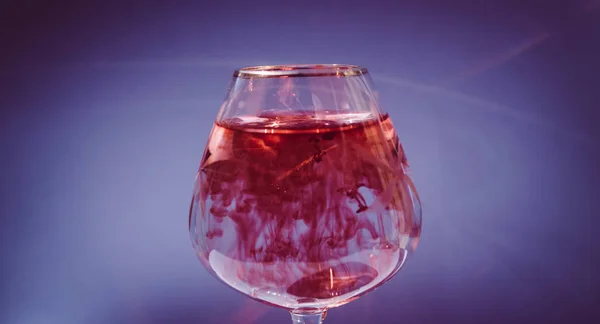 Wijnglas gevuld met rode en gele inkt — Stockfoto