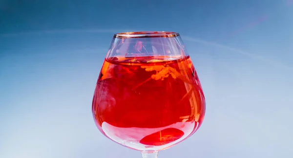 Wine glass filled with red and yellow ink — Foto Stok Gratis