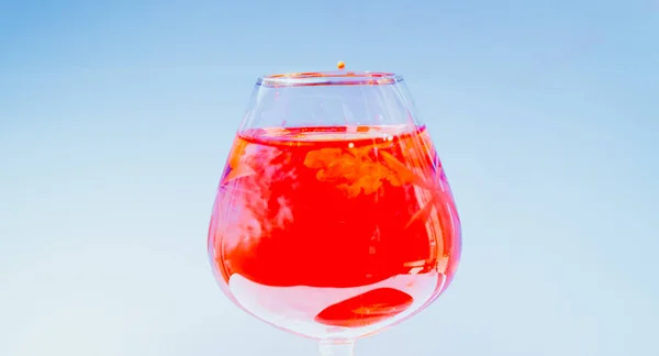 Бокал вина, наполненный красными и желтыми чернилами — стоковое фото