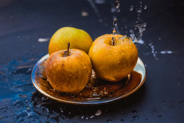 Manzanas en el arroyo de agua de pie en la placa al aire libre — Foto de Stock