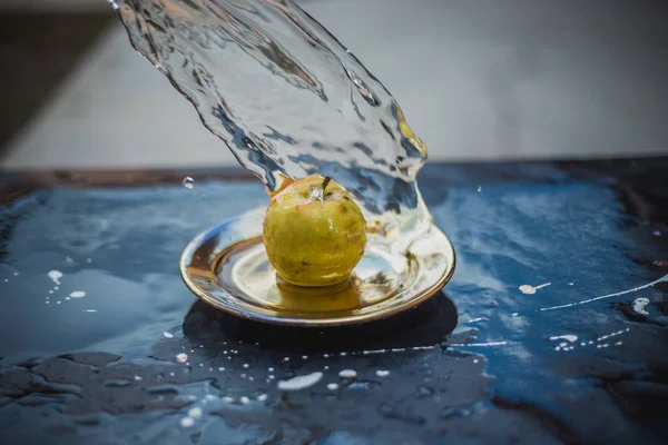 Äpfel im Wasserstrom stehen auf dem Teller im Freien — Stockfoto