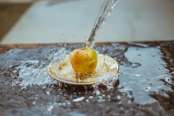 Apples in the water stream standing on the plate outdoors — Free Stock Photo