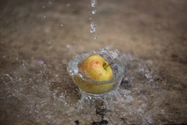 Su akan ve bir bardak düşen elma