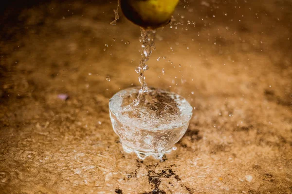 Water stroomt en apple vallen in een glas — Stockfoto