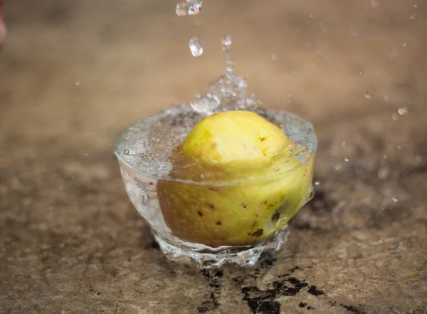 Agua que fluye y manzana que cae en un vaso — Foto de Stock