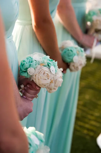 bridesmaid dresses in pastel are holding bouquets