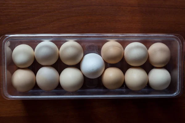 Eggs in a plastic tray on wood backround. Easter eggs.