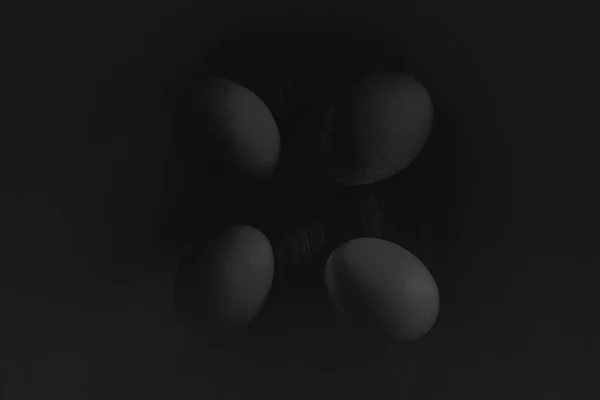 Vejce na dřevěný stůl pozadí. Černá a bílá stylu. Velikonoční vejce. — Stock fotografie
