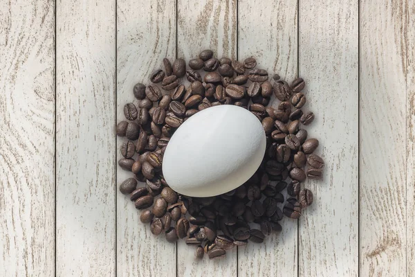 Kaffebönor och påskägg på trä bakgrund — Stockfoto