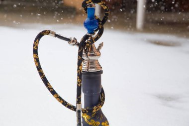 Metal, cam ve seramik yapılmış tütün için büyük nargile. Kar yağıyor. Arka plan kar. Beyaz