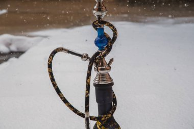 Metal, cam ve seramik yapılmış tütün için büyük nargile. Kar yağıyor. Arka plan kar. Beyaz
