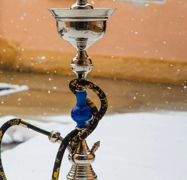 Velká vodní dýmka tabáku vyrobené z kovu, skla a keramiky. Sněží. Sníh na pozadí. Bílá — Stock fotografie