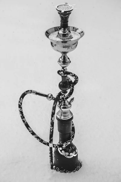 Big hookah for tobacco made of metal, glass and ceramics. Snowing. Snow  background. White — Stock Photo © golib.tolibov.gmail.com #144107355