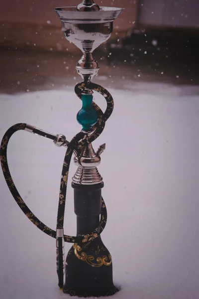 Velká vodní dýmka tabáku vyrobené z kovu, skla a keramiky. Sněží. Sníh na pozadí. Bílá — Stock fotografie