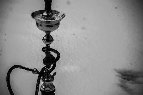 Grande narghilè per tabacco in metallo, vetro e ceramica. Sta nevicando. Fondo neve. Bianco — Foto Stock