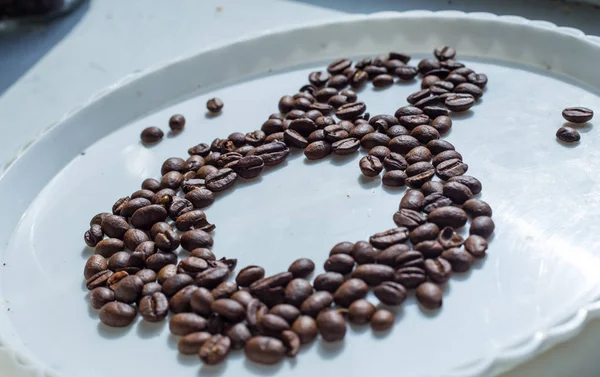 Granos de café en forma de número ocho y orquídeas en plato de plástico blanco. Día Internacional de la Mujer. 8 de marzo — Foto de Stock