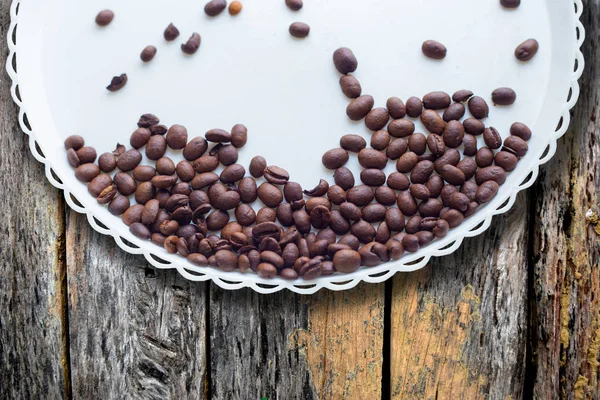 Kaffebönor på en vit plast platta. På beautifull trä bakgrund. Kärlek. Insparation. På vit platta. — Stockfoto