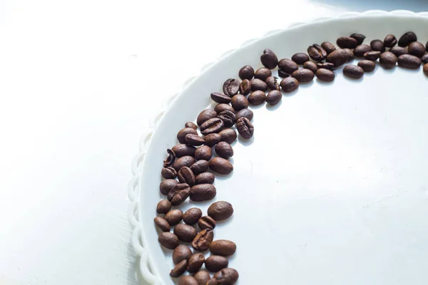 Boabe de cafea în formă de lună pe placa albă — Fotografie, imagine de stoc