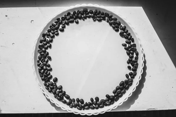 Coffee beans in round shape on the white plate