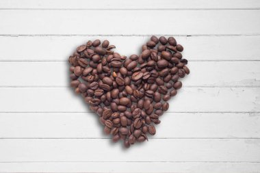 Kahve çekirdekleri güzel arka plan üzerinde kalp şeklinde. Seviyorum. Insparation. Ahşap arka plan üzerinde.