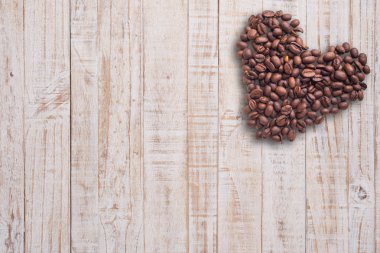 Kahve çekirdekleri güzel arka plan üzerinde kalp şeklinde. Seviyorum. Insparation. Ahşap arka plan üzerinde.